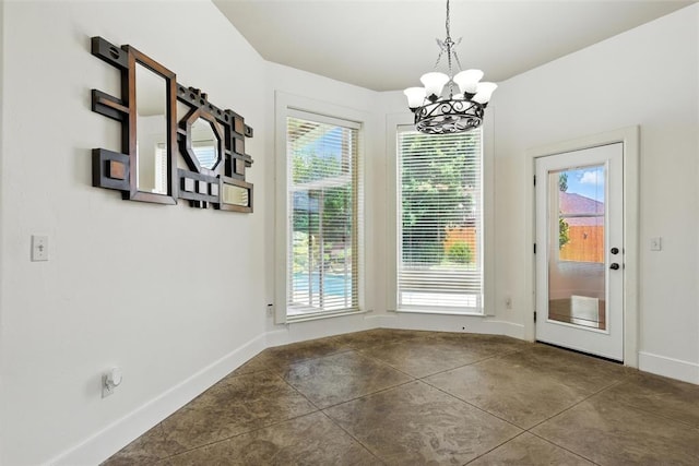 15016 Kurdson Way, Edmond, OK 73013 - unfurnished dining area with a chandelier, healthy amount of natural light, and concrete floors