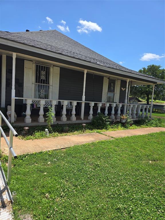 4255 SE 120th Ave, Norman, OK 73026 - view of front of home featuring a porch, a front lawn, and a shingled roof