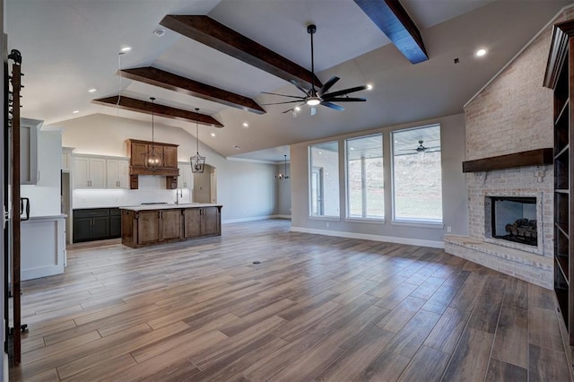 13337 SE 95th St, Oklahoma City, OK 73165 - unfurnished living room with a ceiling fan, a brick fireplace, beam ceiling, light wood-style floors, and high vaulted ceiling