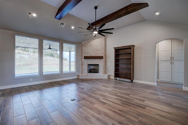 13337 SE 95th St, Oklahoma City, OK 73165 - unfurnished living room featuring ceiling fan, a brick fireplace, wood finished floors, arched walkways, and recessed lighting