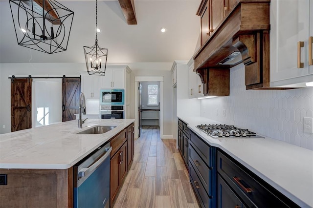 13337 SE 95th St, Oklahoma City, OK 73165 - kitchen with stainless steel appliances, backsplash, a barn door, white cabinetry, and an island with sink
