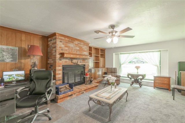 1404 Oak Dr, Edmond, OK 73034 - living room featuring an office area, a brick fireplace, carpet, wooden walls, and ceiling fan