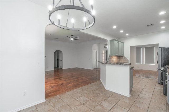 201 NW 160th Ter, Edmond, OK 73013 - kitchen featuring arched walkways, open floor plan, light tile patterned floors, ceiling fan, and recessed lighting