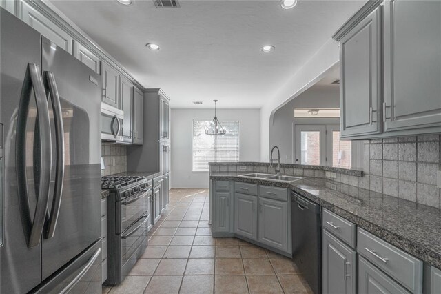 201 NW 160th Ter, Edmond, OK 73013 - kitchen with stainless steel appliances, gray cabinetry, decorative backsplash, recessed lighting, and a peninsula