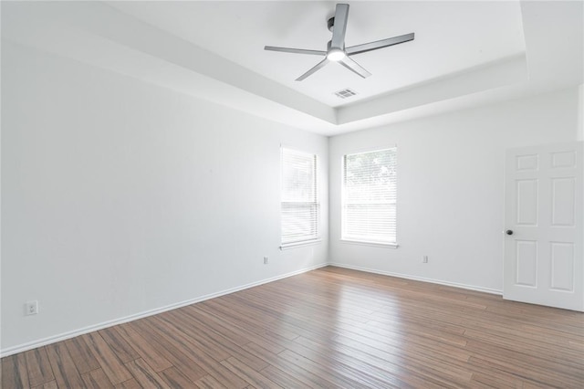 201 NW 160th Ter, Edmond, OK 73013 - spare room with a tray ceiling, ceiling fan, and wood finished floors
