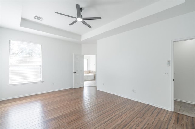 201 NW 160th Ter, Edmond, OK 73013 - spare room featuring a raised ceiling, ceiling fan, and wood finished floors