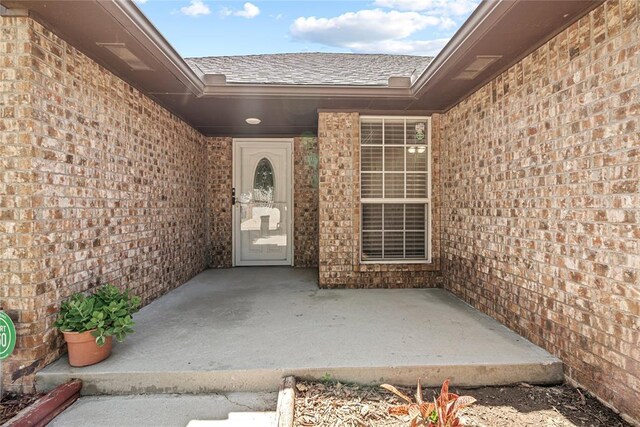 4705 Stag Horn Dr, Yukon, OK 73099 - entrance to property with brick siding, a patio area, and a shingled roof