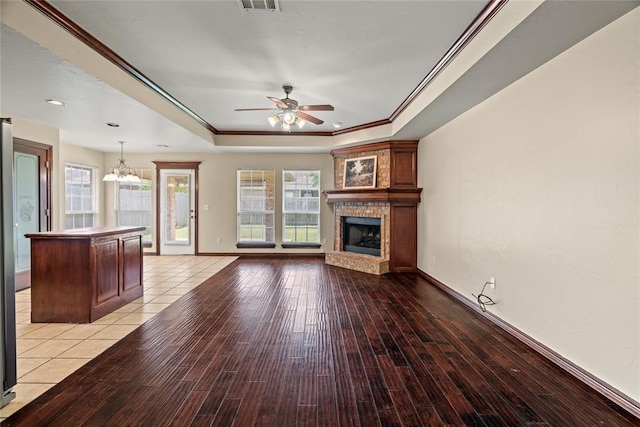 4705 Stag Horn Dr, Yukon, OK 73099 - unfurnished living room featuring a chandelier, ceiling fan, a raised ceiling, a brick fireplace, and crown molding