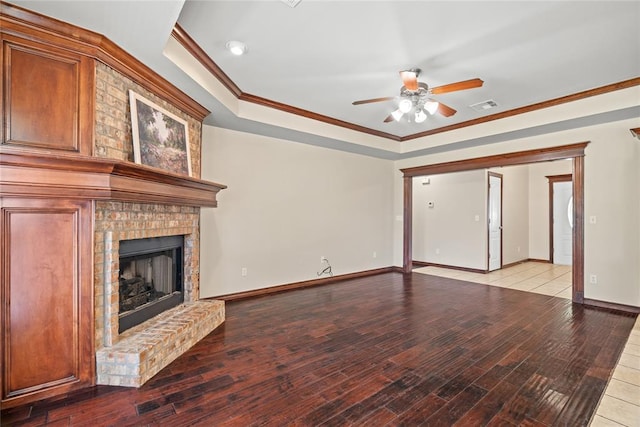 4705 Stag Horn Dr, Yukon, OK 73099 - unfurnished living room featuring ceiling fan, a brick fireplace, a raised ceiling, light wood-type flooring, and ornamental molding