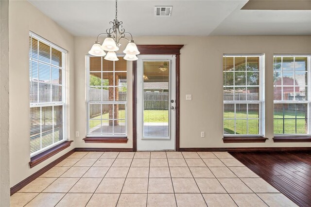 4705 Stag Horn Dr, Yukon, OK 73099 - doorway to outside featuring a chandelier, healthy amount of natural light, and light tile patterned flooring