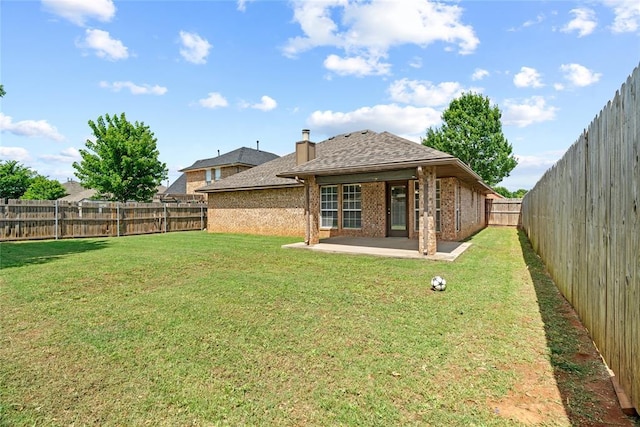 4705 Stag Horn Dr, Yukon, OK 73099 - back of house with a patio area, brick siding, a fenced backyard, a chimney, and roof with shingles