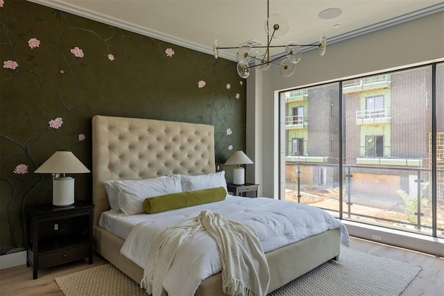 907 NW 9th St Unit B, Oklahoma City, OK 73106 - bedroom with a chandelier, wood finished floors, crown molding, wallpapered walls, and access to exterior