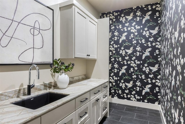 907 NW 9th St Unit B, Oklahoma City, OK 73106 - kitchen featuring white cabinetry, dark tile patterned floors, light stone counters, and wallpapered walls