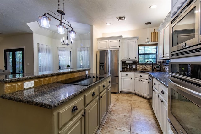 10517 SE 49th St, Oklahoma City, OK 73150 - kitchen featuring stainless steel appliances, tasteful backsplash, decorative light fixtures, a chandelier, and a kitchen island