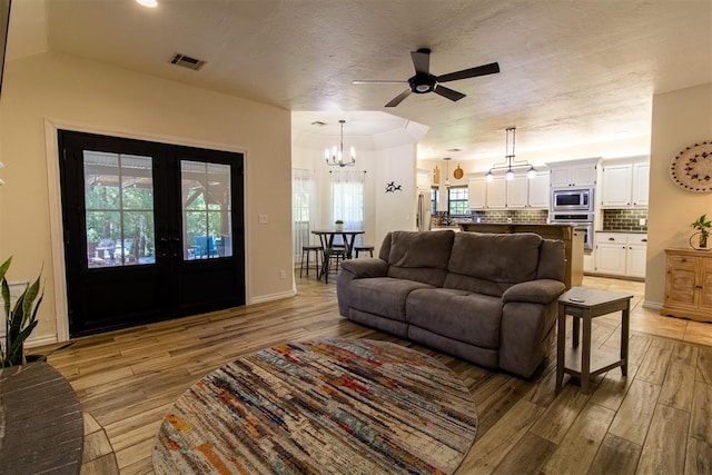 10517 SE 49th St, Oklahoma City, OK 73150 - living area with french doors, a chandelier, light wood-style flooring, and a ceiling fan