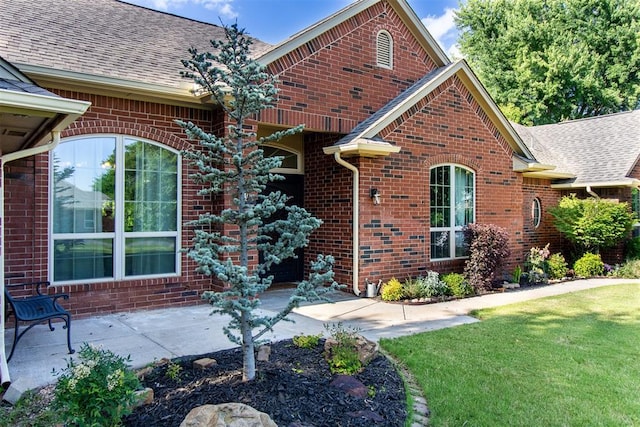 10517 SE 49th St, Oklahoma City, OK 73150 - view of front facade featuring a shingled roof, brick siding, a front yard, and a patio area