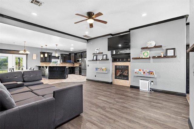 5901 NE Watts Rd, Elgin, OK 73538 - living area featuring a ceiling fan, wood finished floors, a fireplace, and recessed lighting