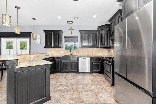 5901 NE Watts Rd, Elgin, OK 73538 - kitchen with appliances with stainless steel finishes, a peninsula, dark cabinetry, and backsplash