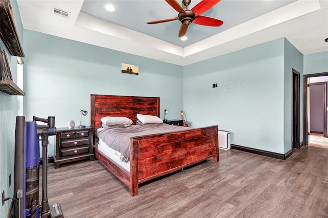 5901 NE Watts Rd, Elgin, OK 73538 - bedroom featuring a raised ceiling, wood finished floors, recessed lighting, and a ceiling fan