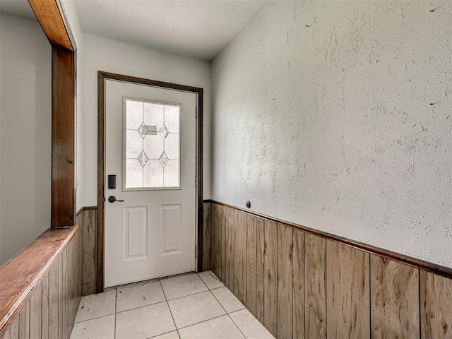 356818 E 1070th Rd, Prague, OK 74864 - doorway to outside featuring a wainscoted wall, light tile patterned floors, and wooden walls