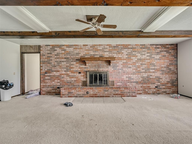 356818 E 1070th Rd, Prague, OK 74864 - unfurnished living room featuring a fireplace, carpet, ceiling fan, brick wall, and beam ceiling