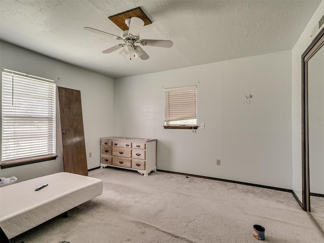 356818 E 1070th Rd, Prague, OK 74864 - bedroom featuring multiple windows, light colored carpet, a textured ceiling, and a ceiling fan