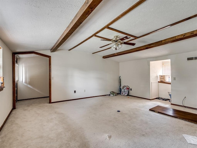 356818 E 1070th Rd, Prague, OK 74864 - unfurnished living room featuring a textured ceiling, beamed ceiling, ceiling fan, and carpet flooring