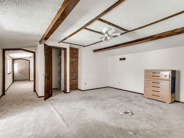 356818 E 1070th Rd, Prague, OK 74864 - unfurnished living room with light colored carpet, a textured ceiling, beam ceiling, and ceiling fan