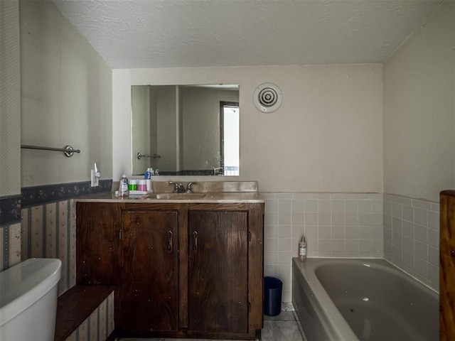 356818 E 1070th Rd, Prague, OK 74864 - bathroom featuring a bath, a textured ceiling, a wainscoted wall, vanity, and tile patterned floors