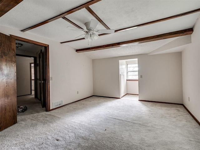 356818 E 1070th Rd, Prague, OK 74864 - empty room featuring carpet flooring, beam ceiling, a ceiling fan, and a textured ceiling