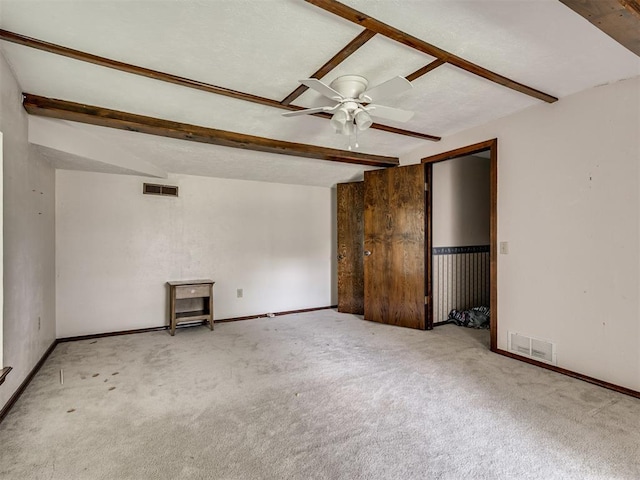 356818 E 1070th Rd, Prague, OK 74864 - unfurnished bedroom with beamed ceiling, carpet flooring, and a ceiling fan