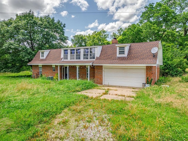 356818 E 1070th Rd, Prague, OK 74864 - view of front of house featuring brick siding, a garage, a chimney, driveway, and covered porch