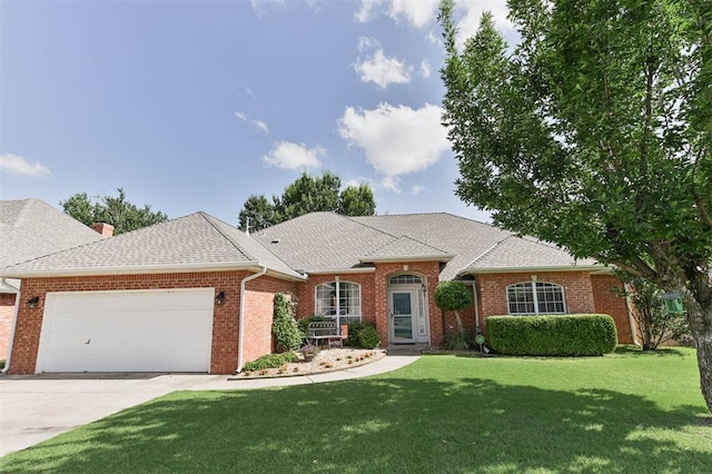 2704 Jills Trl, Edmond, OK 73012 - view of front of house featuring a garage, a front yard, concrete driveway, brick siding, and roof with shingles