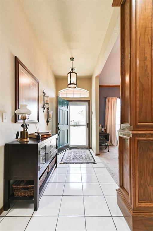 2704 Jills Trl, Edmond, OK 73012 - foyer featuring plenty of natural light, light tile patterned flooring, and light carpet