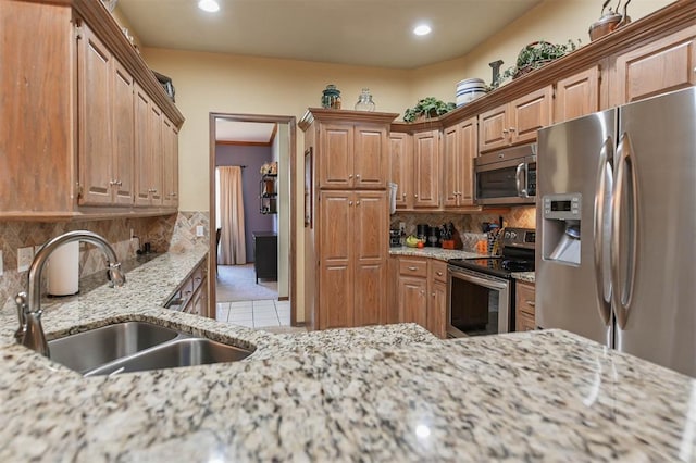 2704 Jills Trl, Edmond, OK 73012 - kitchen featuring appliances with stainless steel finishes, backsplash, light stone countertops, light tile patterned flooring, and recessed lighting