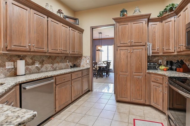 2704 Jills Trl, Edmond, OK 73012 - kitchen with stainless steel dishwasher, electric range, light tile patterned floors, and light stone counters