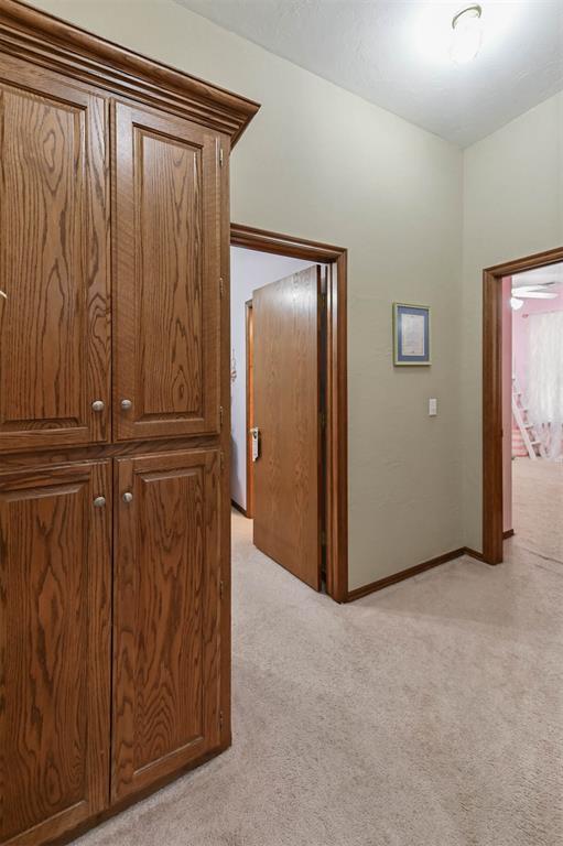 2704 Jills Trl, Edmond, OK 73012 - corridor with light carpet and baseboards
