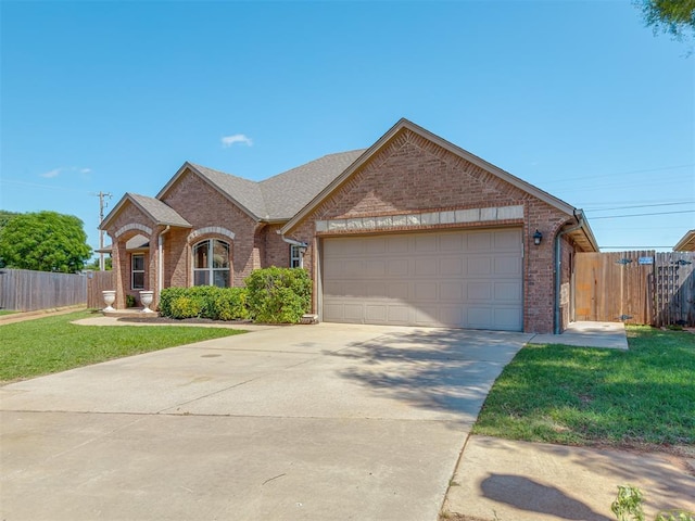 11749 SW 16th St, Yukon, OK 73099 - view of front facade featuring brick siding, an attached garage, and driveway