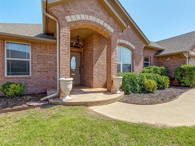 11749 SW 16th St, Yukon, OK 73099 - entrance to property featuring brick siding, a shingled roof, and a yard