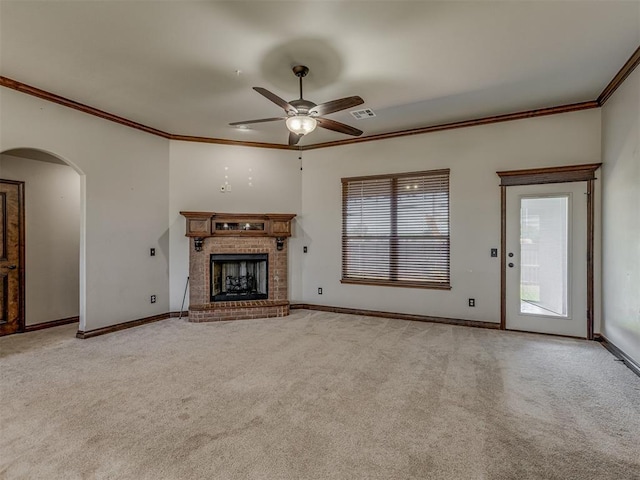11749 SW 16th St, Yukon, OK 73099 - unfurnished living room with crown molding, ceiling fan, arched walkways, light colored carpet, and a fireplace