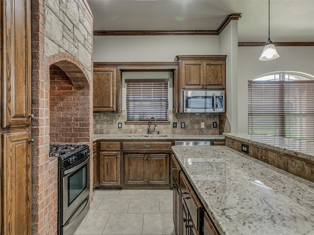 11749 SW 16th St, Yukon, OK 73099 - kitchen with appliances with stainless steel finishes, ornamental molding, tasteful backsplash, light stone counters, and light tile patterned floors