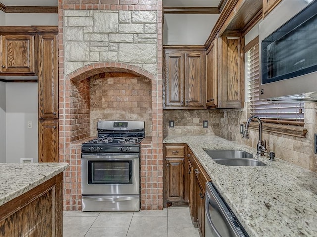 11749 SW 16th St, Yukon, OK 73099 - kitchen with stainless steel appliances, crown molding, backsplash, light tile patterned floors, and light stone countertops