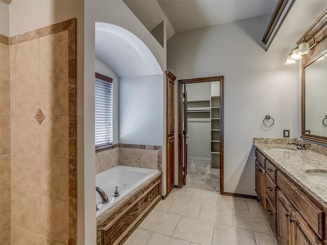 11749 SW 16th St, Yukon, OK 73099 - full bathroom featuring a bath, vaulted ceiling, double vanity, a walk in closet, and tile patterned floors