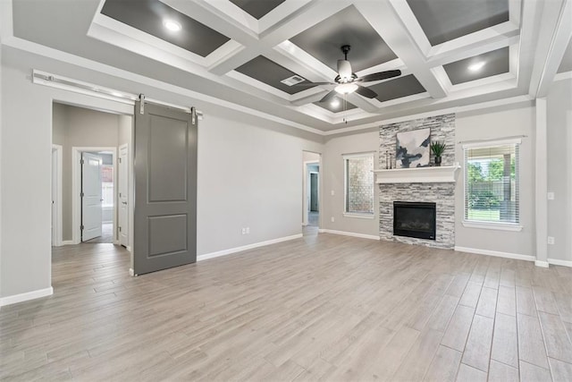 12904 SW 8th St, Yukon, OK 73099 - unfurnished living room with ceiling fan, a barn door, light wood-style flooring, a fireplace, and coffered ceiling
