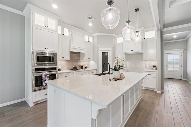 12904 SW 8th St, Yukon, OK 73099 - kitchen featuring stainless steel appliances, light wood-type flooring, white cabinets, a large island, and tasteful backsplash