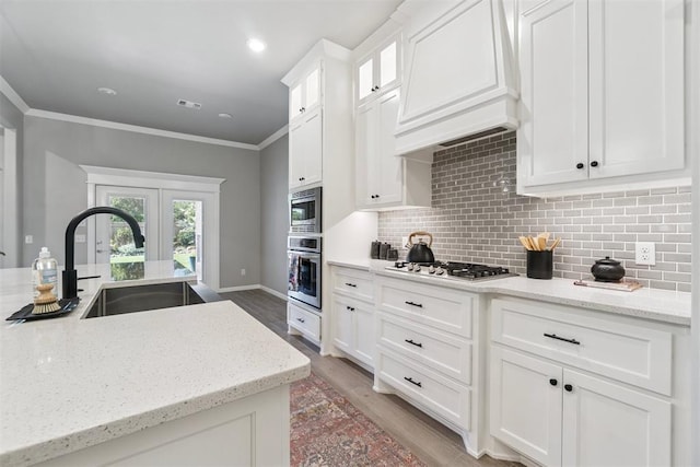 12904 SW 8th St, Yukon, OK 73099 - kitchen with custom exhaust hood, appliances with stainless steel finishes, french doors, white cabinetry, and tasteful backsplash