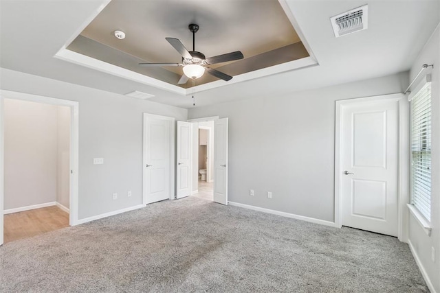 12904 SW 8th St, Yukon, OK 73099 - unfurnished bedroom featuring a tray ceiling, carpet, and a ceiling fan
