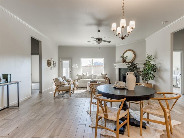 11700 SW 15th Ter, Yukon, OK 73099 - dining room featuring ornamental molding, ceiling fan, light wood finished floors, a chandelier, and a tile fireplace