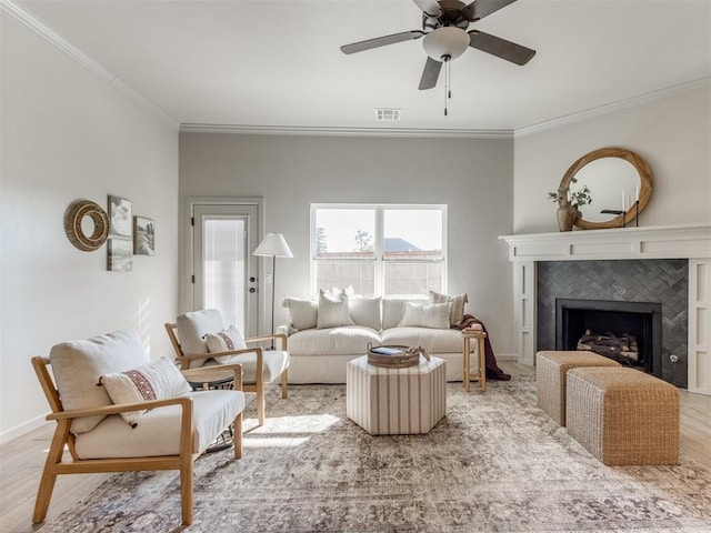 11700 SW 15th Ter, Yukon, OK 73099 - living area with crown molding, ceiling fan, light wood-style flooring, and a tile fireplace
