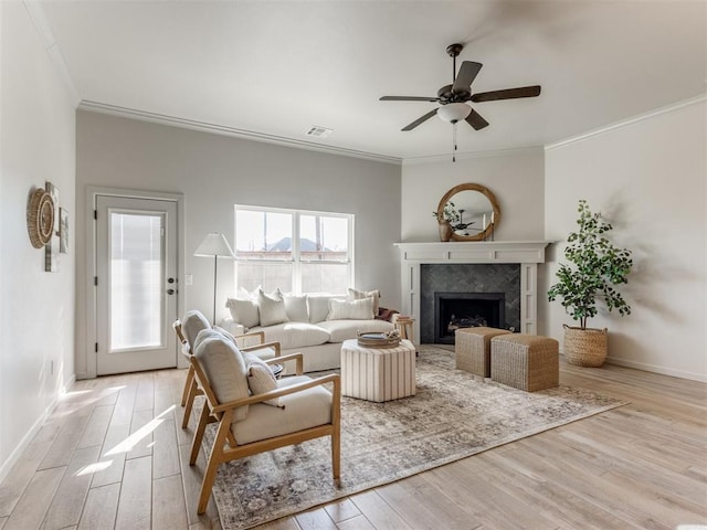 11700 SW 15th Ter, Yukon, OK 73099 - living room featuring light wood-type flooring, a ceiling fan, crown molding, and a tile fireplace
